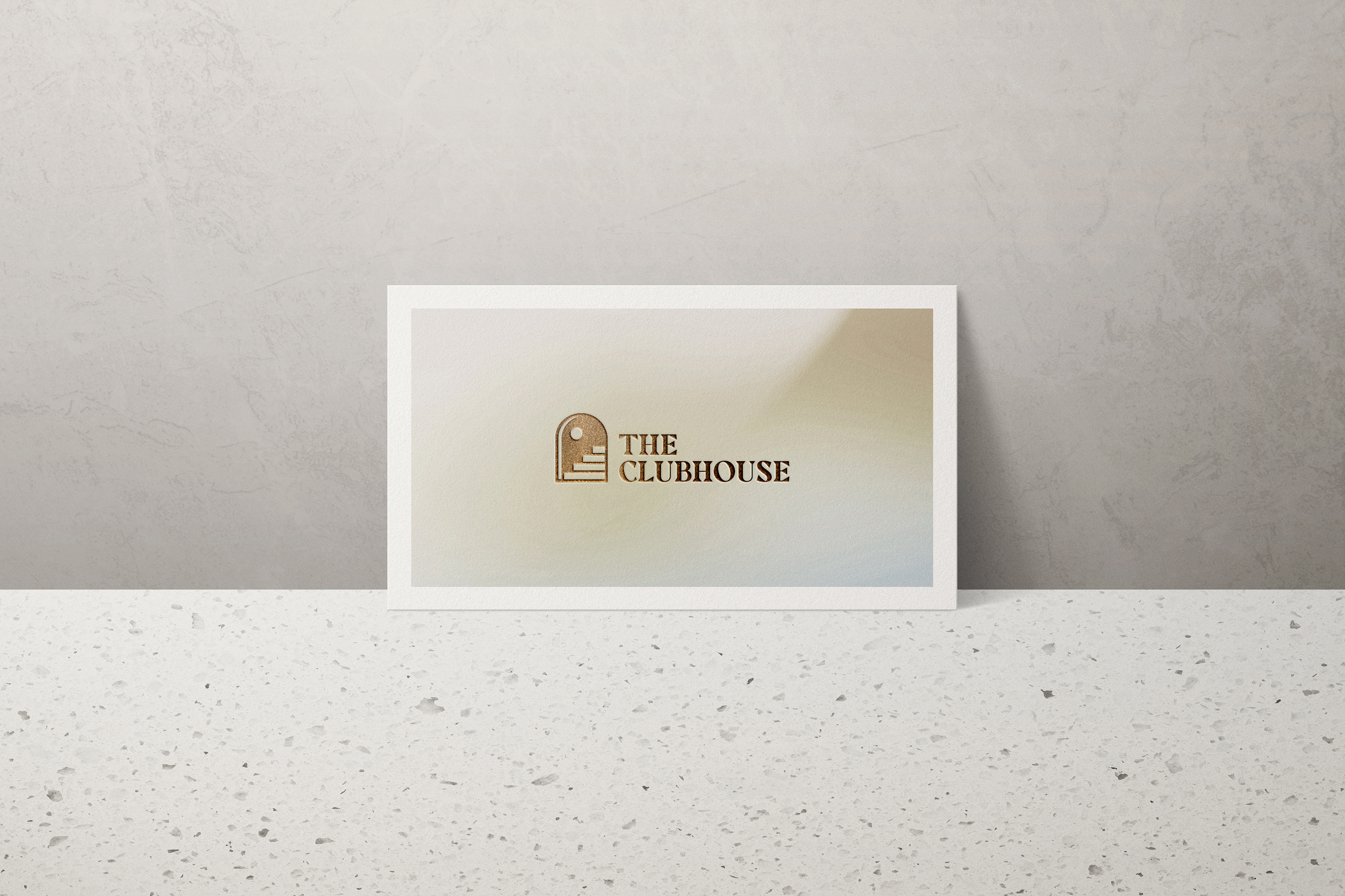 The front of The Clubhouse business card leaning on a grey wall