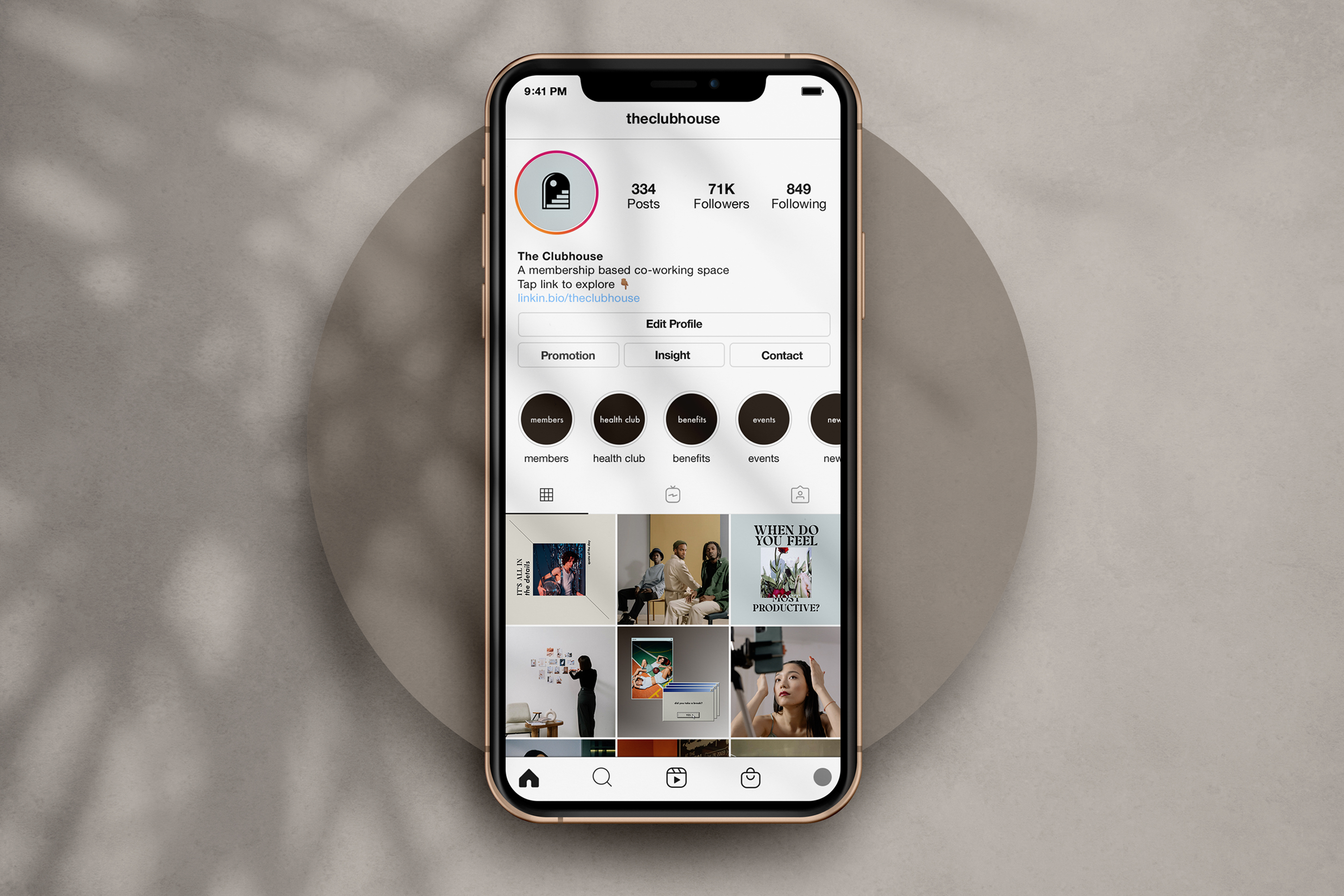 A rose gold iPhone displaying The Clubhouse instagram profile on a beige circle base