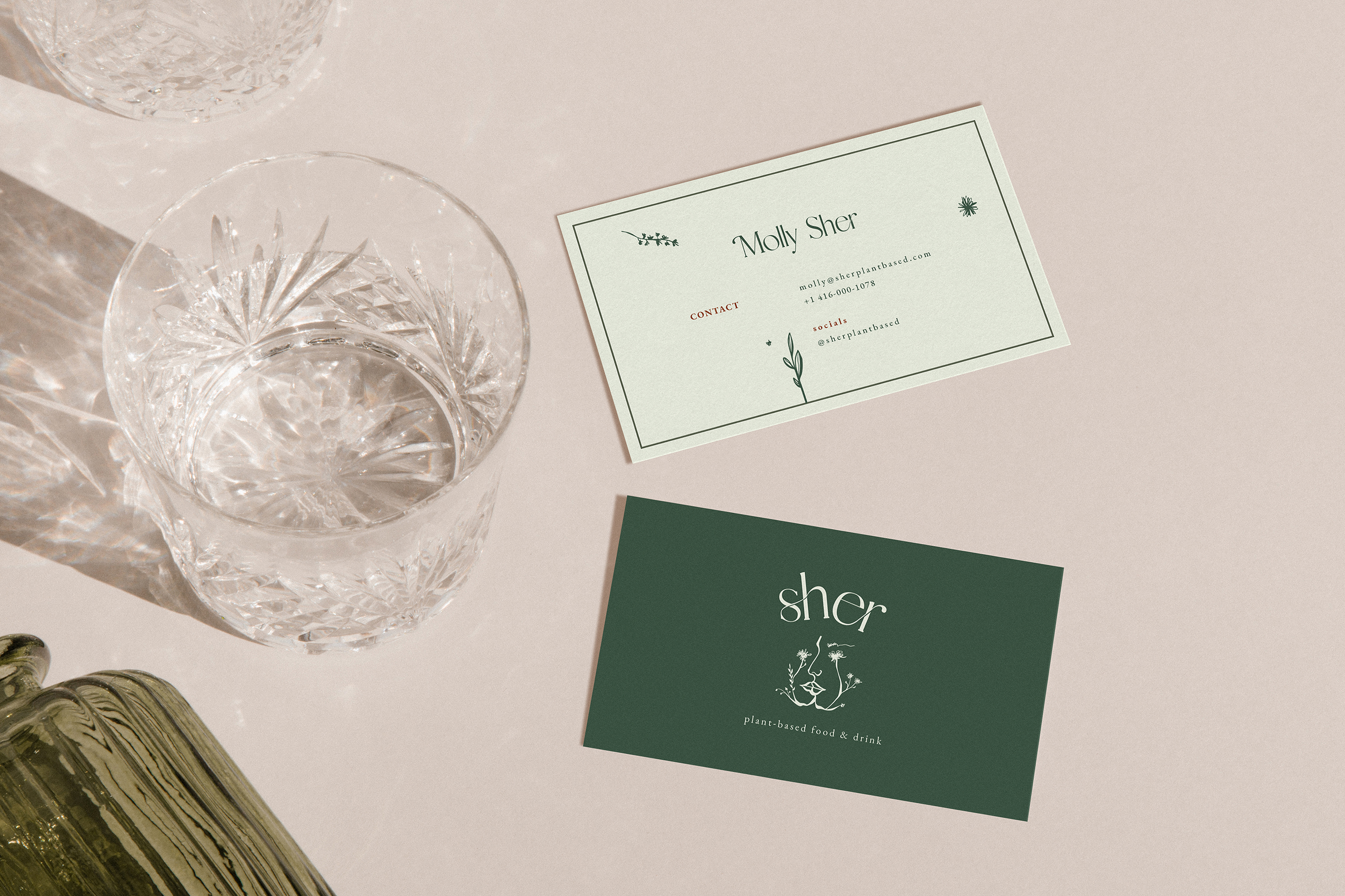 Overhead shot of the front and back of a green Sher business card