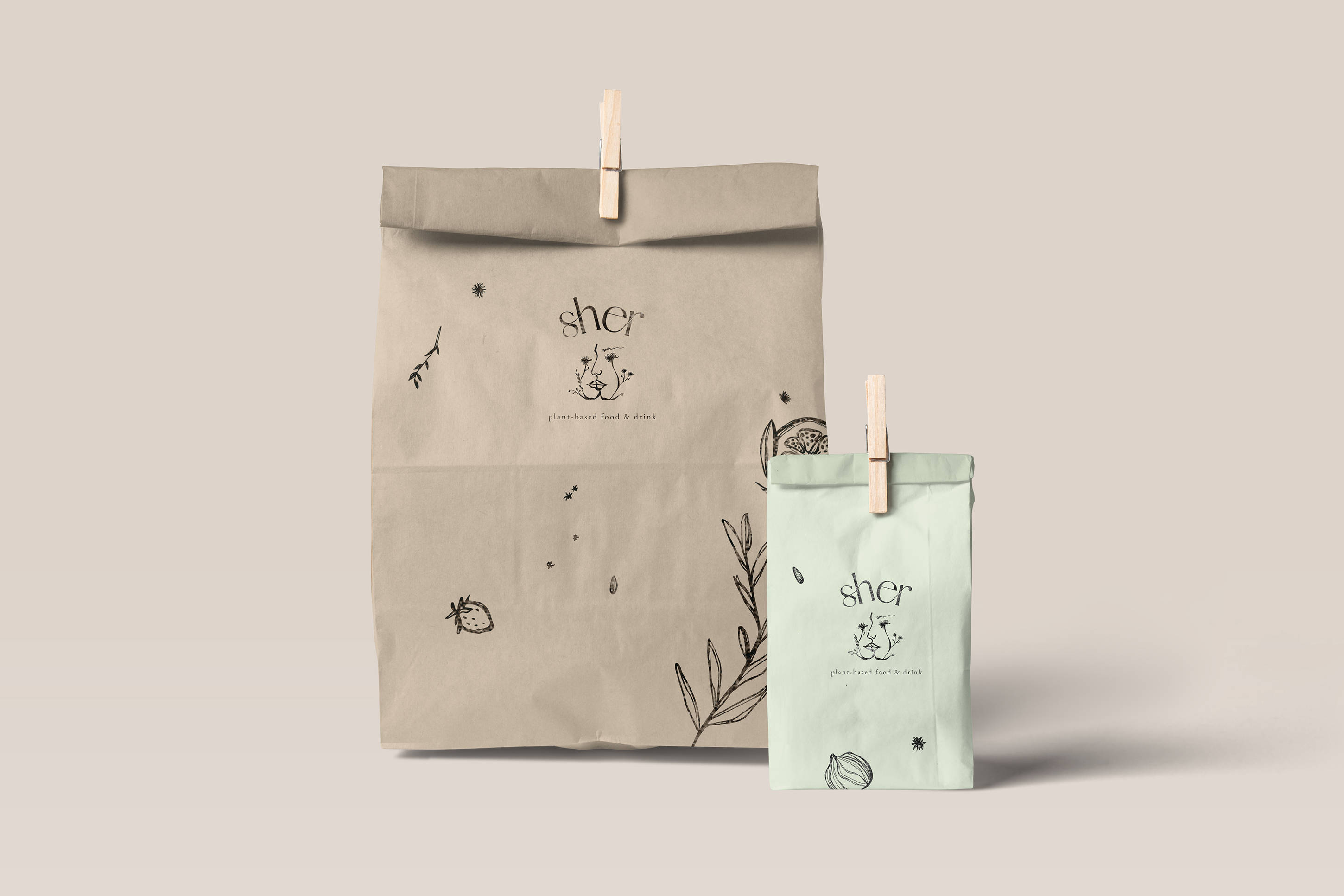 Two takeaway paper bags with the Sher logo and several different illustrations stamped on them